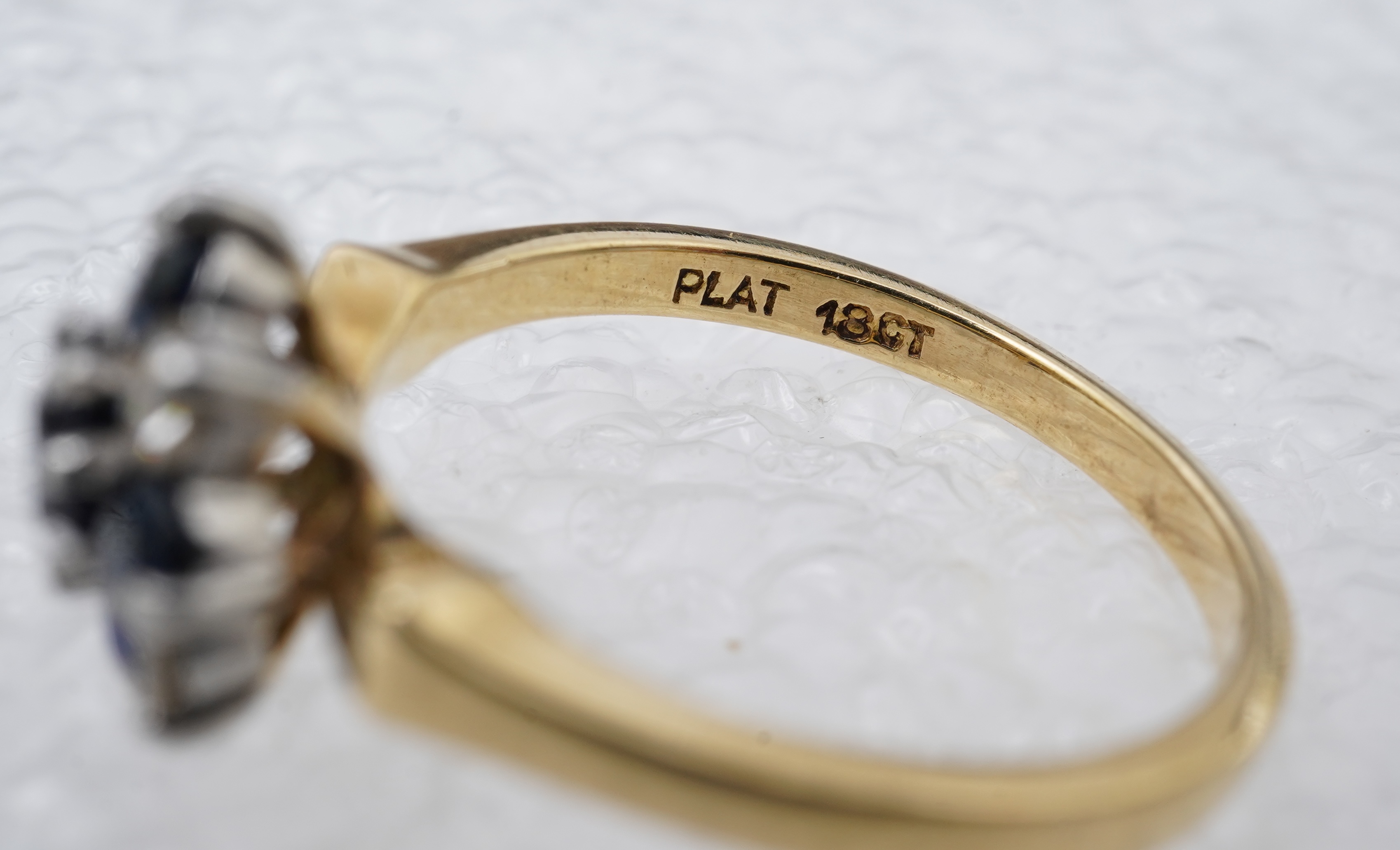 A sapphire and diamond cluster ring, set with circular-cut sapphires and brilliant-cut diamonds totalling approximately 0.20 carats, mounted in gold and platinum, size M, stamped 18CT PLAT, gross weight approximately 3.5